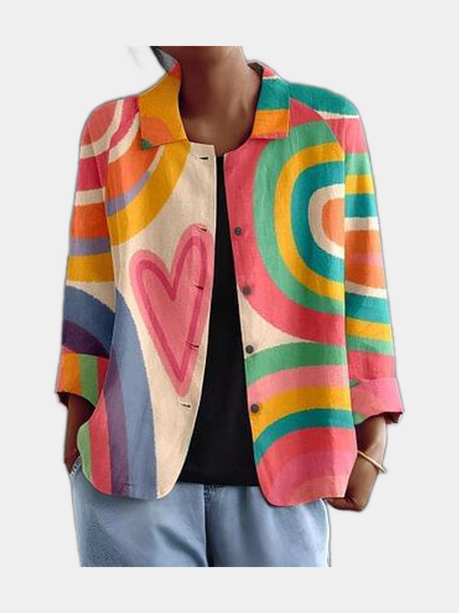 Open blouse in painted arcs of pink, coral, teal and yellow with a heart at the front, worn over a black top