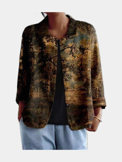 Open blouse printed with a dark painterly landscape of trees in bronze, olive and gold, worn over a black top