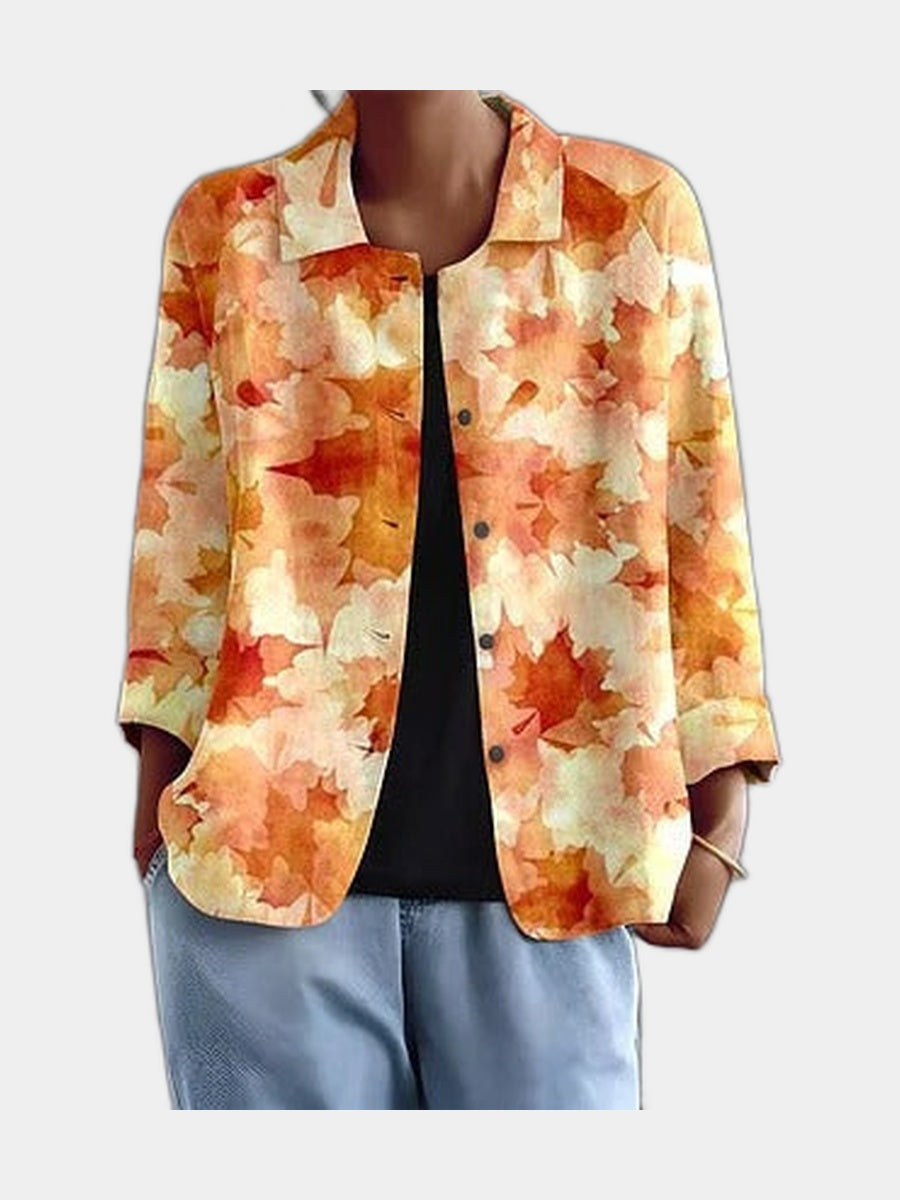 Open blouse with watercolour leaves in amber and apricot, worn over a black top