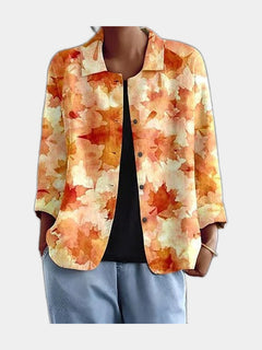 Open blouse with watercolour leaves in amber and apricot, worn over a black top