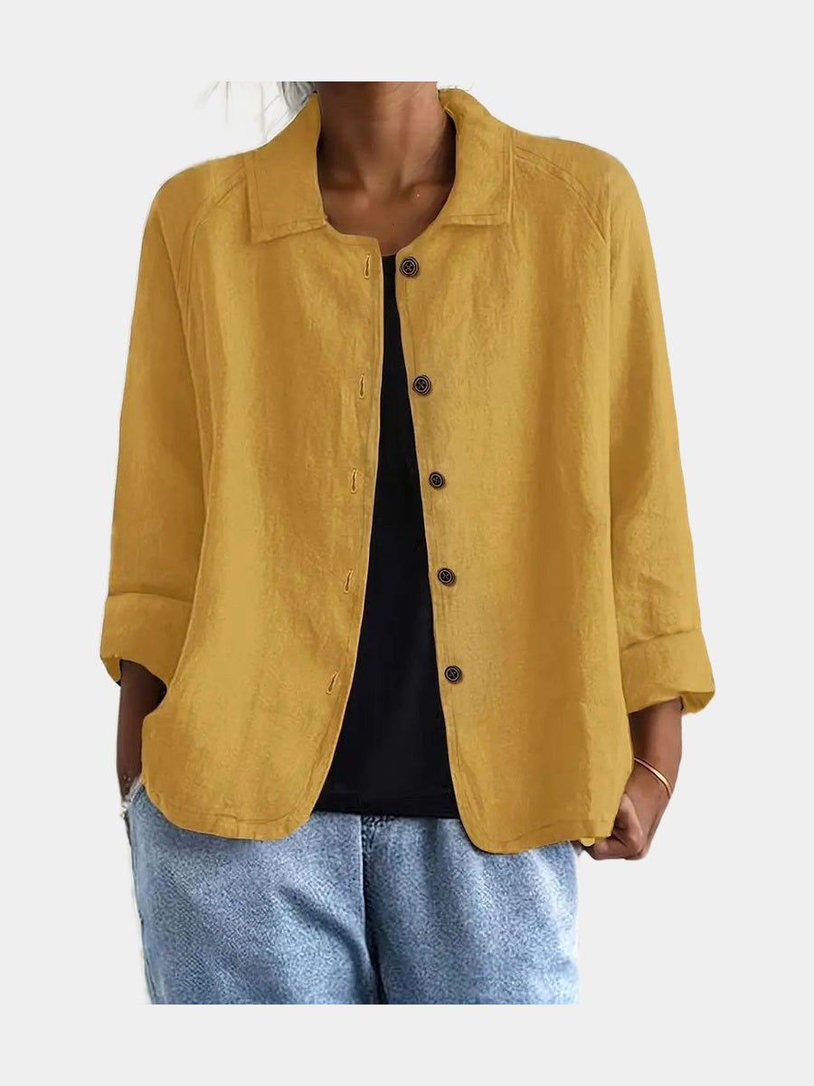 Open blouse in warm ochre with a lightly slubbed surface, worn over a black top